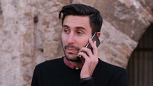 man talking on a cellphone outdoors 