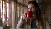 Girl drinking coffee out of a mug.