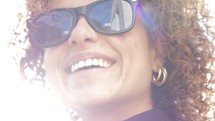 a smiling woman in sunglasses 