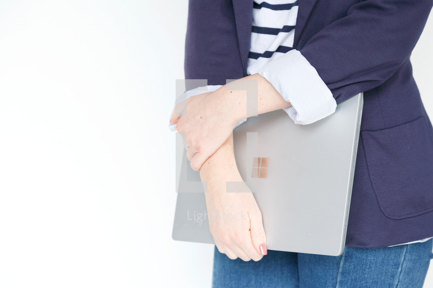 A woman holding a laptop computer 