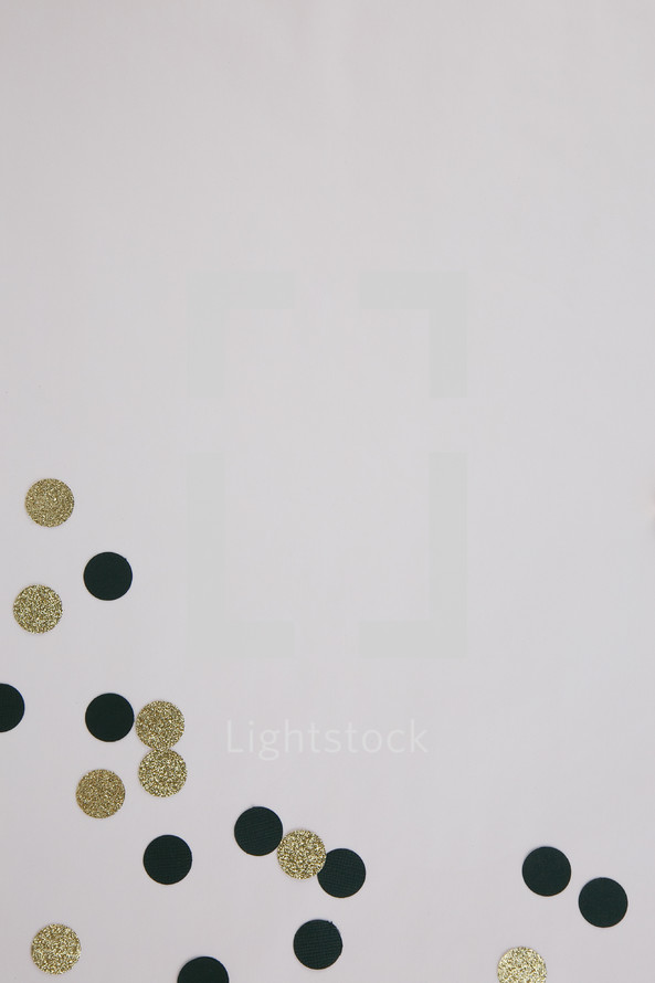 gold and black confetti on white background 