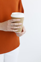 a woman holding a to go cup 
