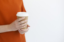 a woman holding a to go coffee cup 