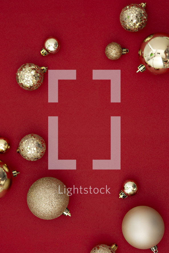 gold Christmas ornaments on a red background 