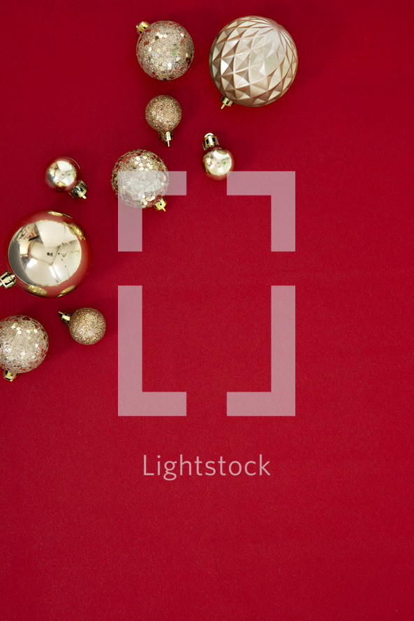 gold Christmas ornaments on a red background 