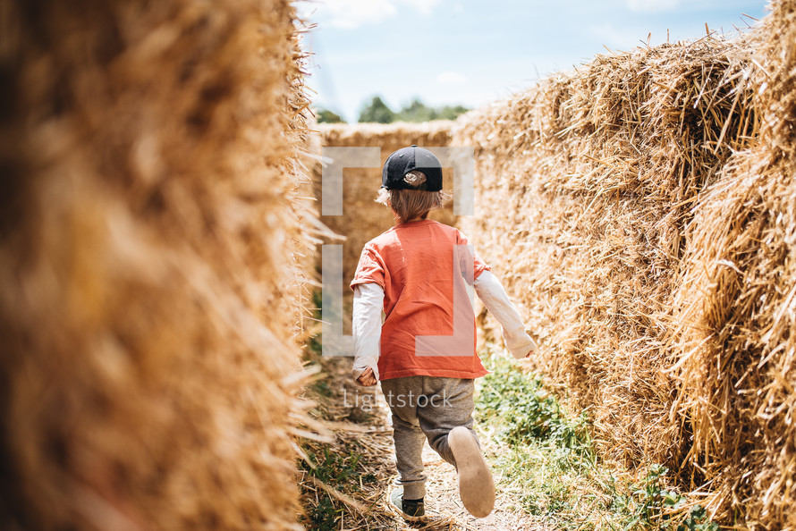 a child exploring a hay maze 