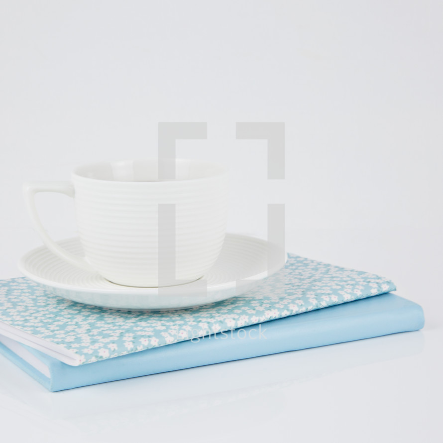 coffee cup on blue and floral planners 