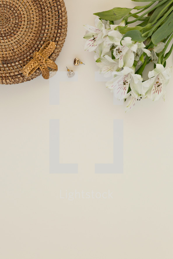 flowers, basket and earrings on a white background 