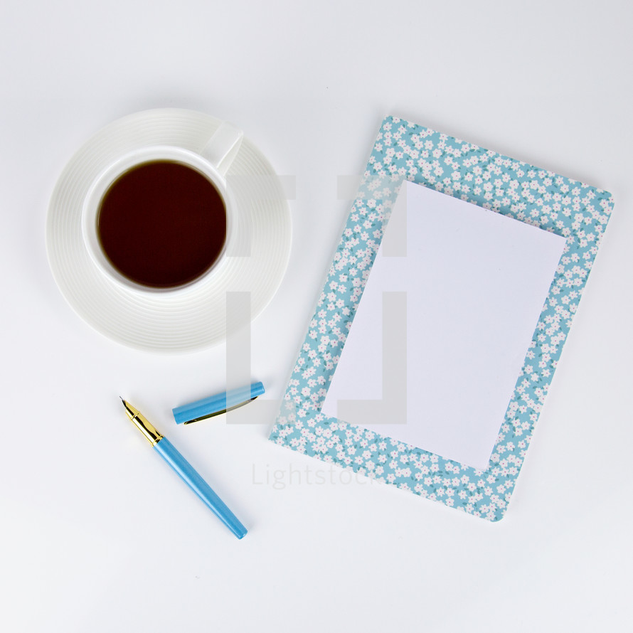 coffee cup, pen, and floral planner 