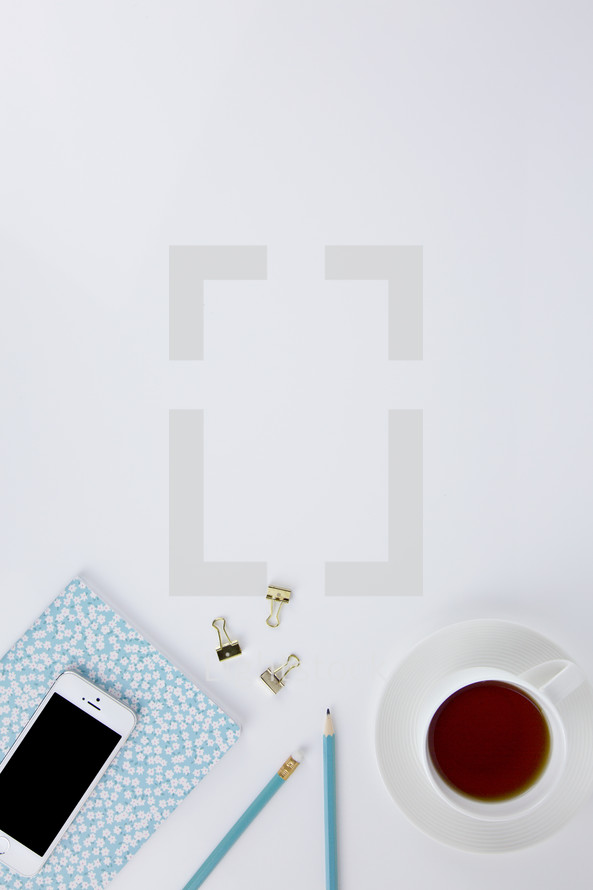 iPhone, planner, clips, coffee cup on a white background 