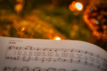 Hymnal turned to Christmas music against bokeh Christmas lights 