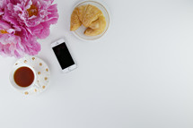 croissant, tea cup, iPhone, and pink flower 