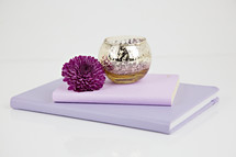 metallic bowl, purple flower, and journals 