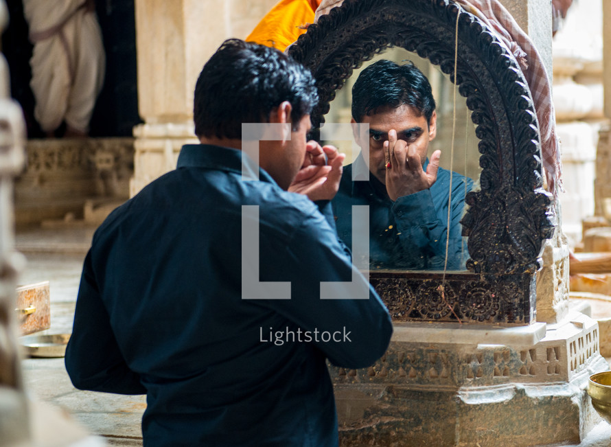 a man looking in the mirror in India 