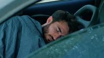 a man sleeping in a car 