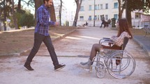 a man having a conversation with a woman in a wheelchair 