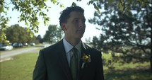 Groom, husband on wedding day wearing tux, suit and boutonniere on wedding day.