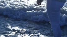a woman scooping water from the ocean in her hands 
