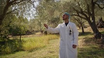 Specialist taking a quality check at a group of olive trees 
