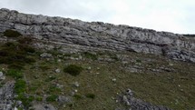 Tracking shot along rocky crag outcrop.