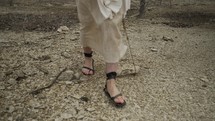 Jesus Christ, bible nomad, Christian prophet, monk or religious man in white tunic and sandals walking in the Jerusalem wilderness in cinematic slow motion.