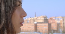 a young woman standing in a city looking out 
