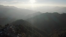 Aerial drone shot over Sierra San Jose del Pacifico in Oaxaca, southwest Mexico on a sunny day. Scenic view over sunlight falling over the mountain range.