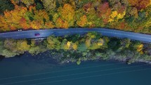 Cars on the highway by the autumn forest