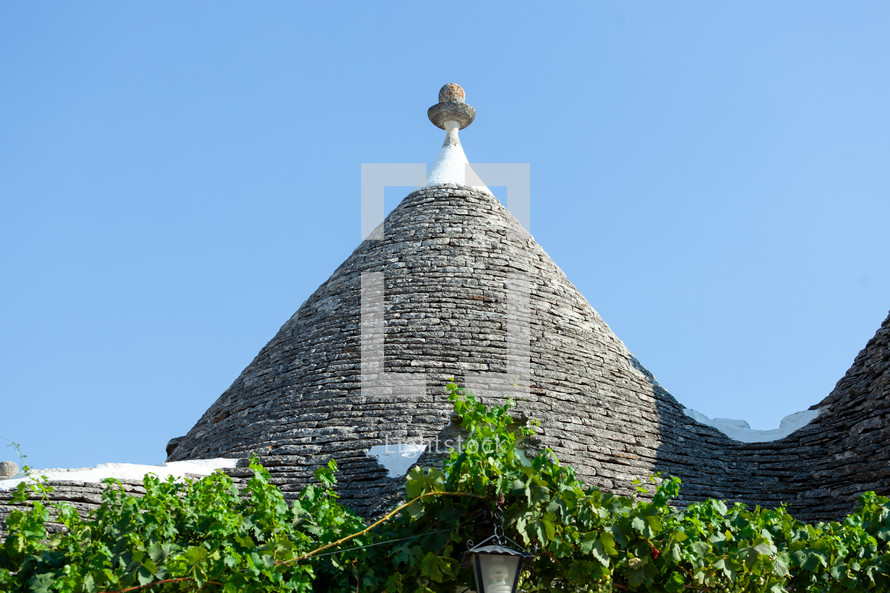 Trulli rooftops are forming a beautiful pattern with the blue sky in the background