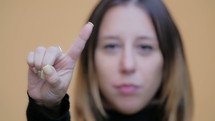 Woman shaking her finger in front of the camera.
