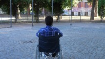 a man in a courtyard in a wheelchair 