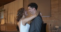 Happy bride and groom dancing together at wedding reception.