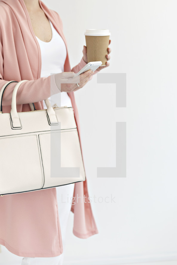 a woman with a purse holding a coffee cup 