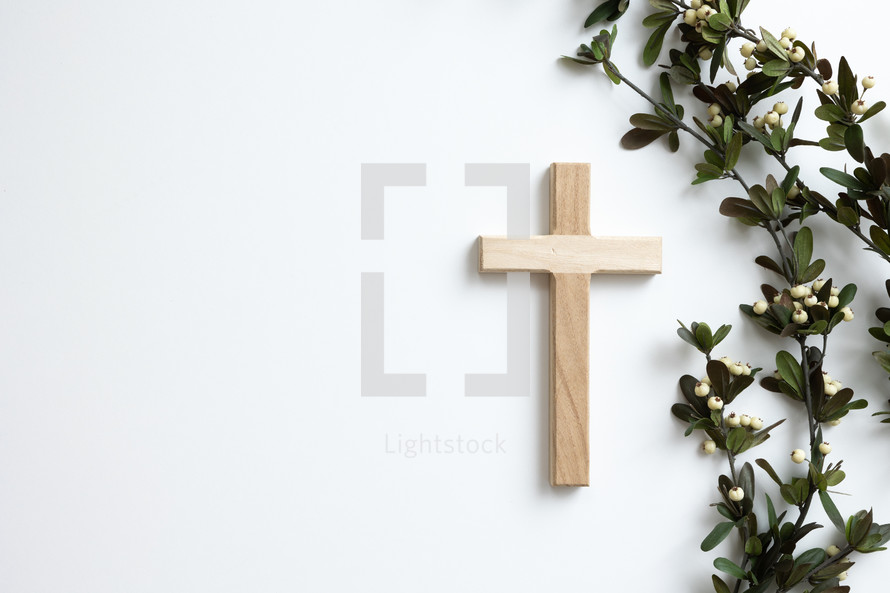 Cross and branch with white berries on a white background