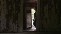 woman walking through an abandoned house 