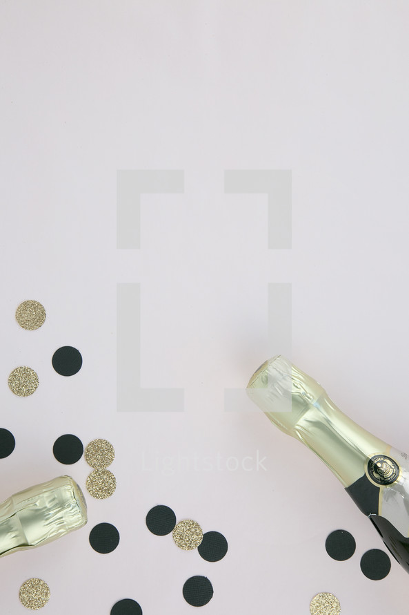 champagne bottles and black and gold confetti 