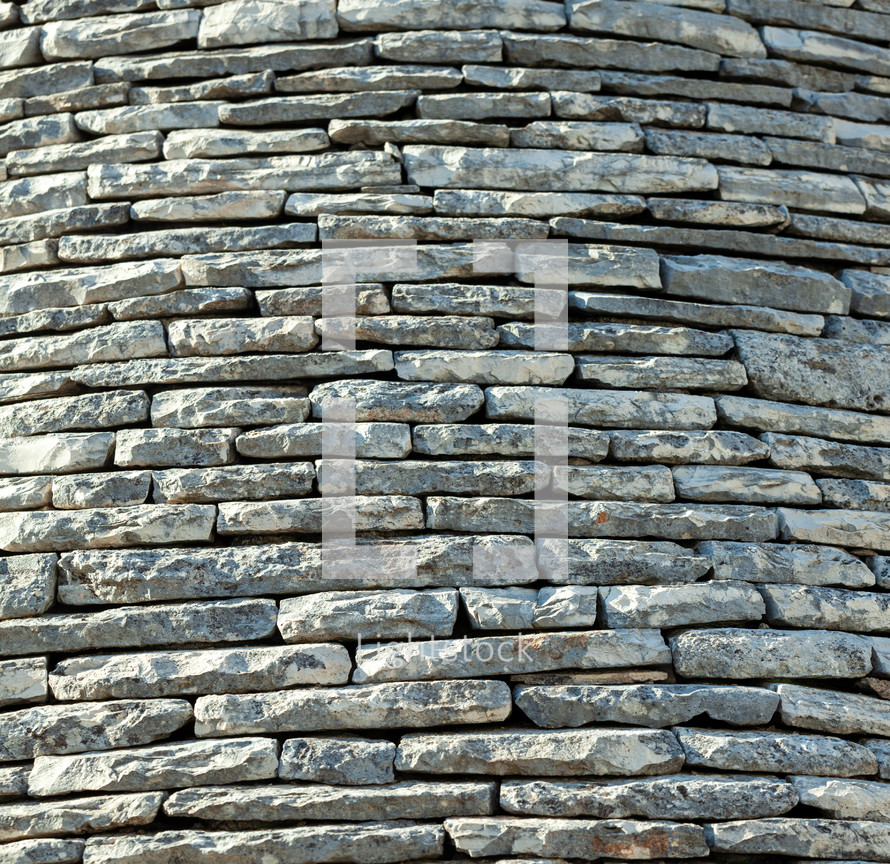 Close up of the typical conic roof of a trulli, made of grey stones, in alberobello, puglia