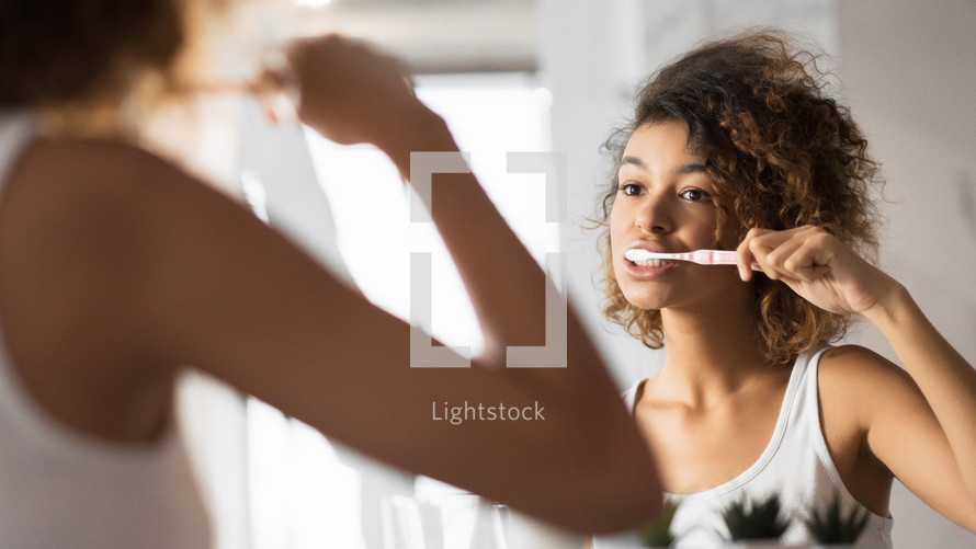 a woman brushing her teeth 
