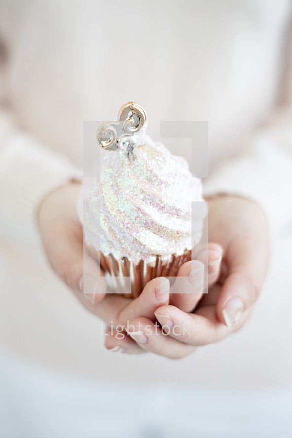 a woman holding a cupcake 