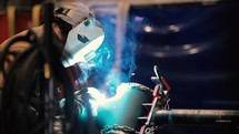 Welder welding together industrial piping 2