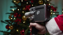 Santa Claus with Super 8 camera moving towards tree