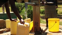 filling a water jug at a well 