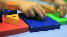 preschool child playing with colorful blocks