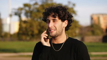 a man talking on a cellphone outdoors 