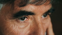 Close up of a gray haired man's eyes as he blinks.