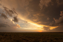 Spectacular Colors Fill The Sky As The Sun Sets Under A Passing Storm Cloud