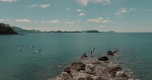 Pelicans On The Rocks At The Beach In Guanacaste, Costa Rica - aerial drone shot	