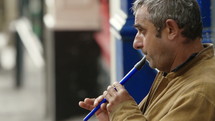 Man playing an instrument on the street.