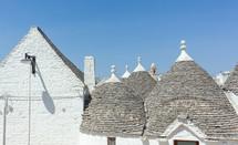 Cluster of traditional trulli houses with conical roofs forming a picturesque cityscape in alberobello, puglia region, italy