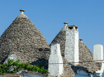 Traditional trulli houses with conical roofs made of stone in alberobello, a unesco world heritage site in puglia, italy, are shining in the sun